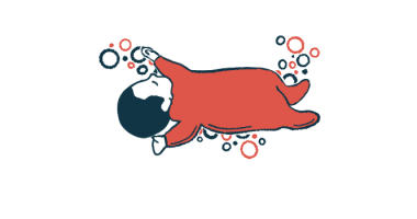 An infant in a red sleeper is seen napping.