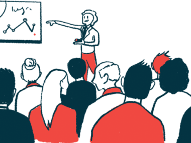A speaker giving a presentation at a conference points to data on a white board.