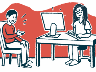 A patient sits in a chair talking to a healthcare provider who is typing on a computer.