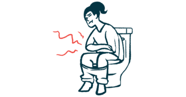 Girl is sitting on a toilet holding her stomach in pain.