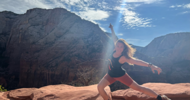 A woman is shown performing a dance move in front of a western landscape.