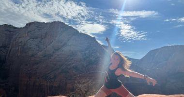 A woman is shown performing a dance move in front of a western landscape.